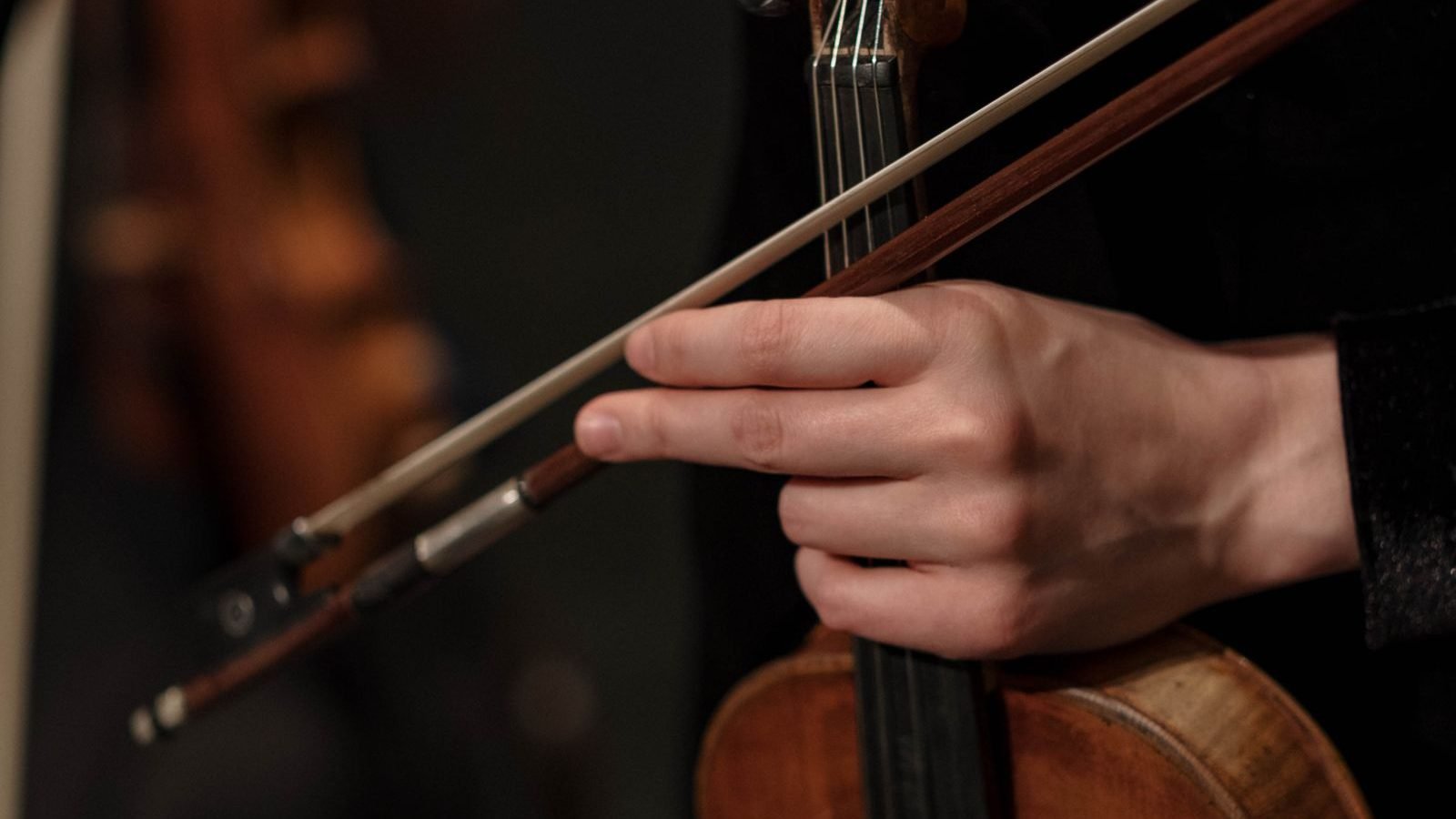 Close-up de mãos tocando violino durante apresentação