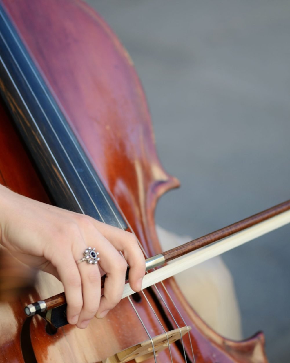 Close-up de mão tocando violoncelo com arco
