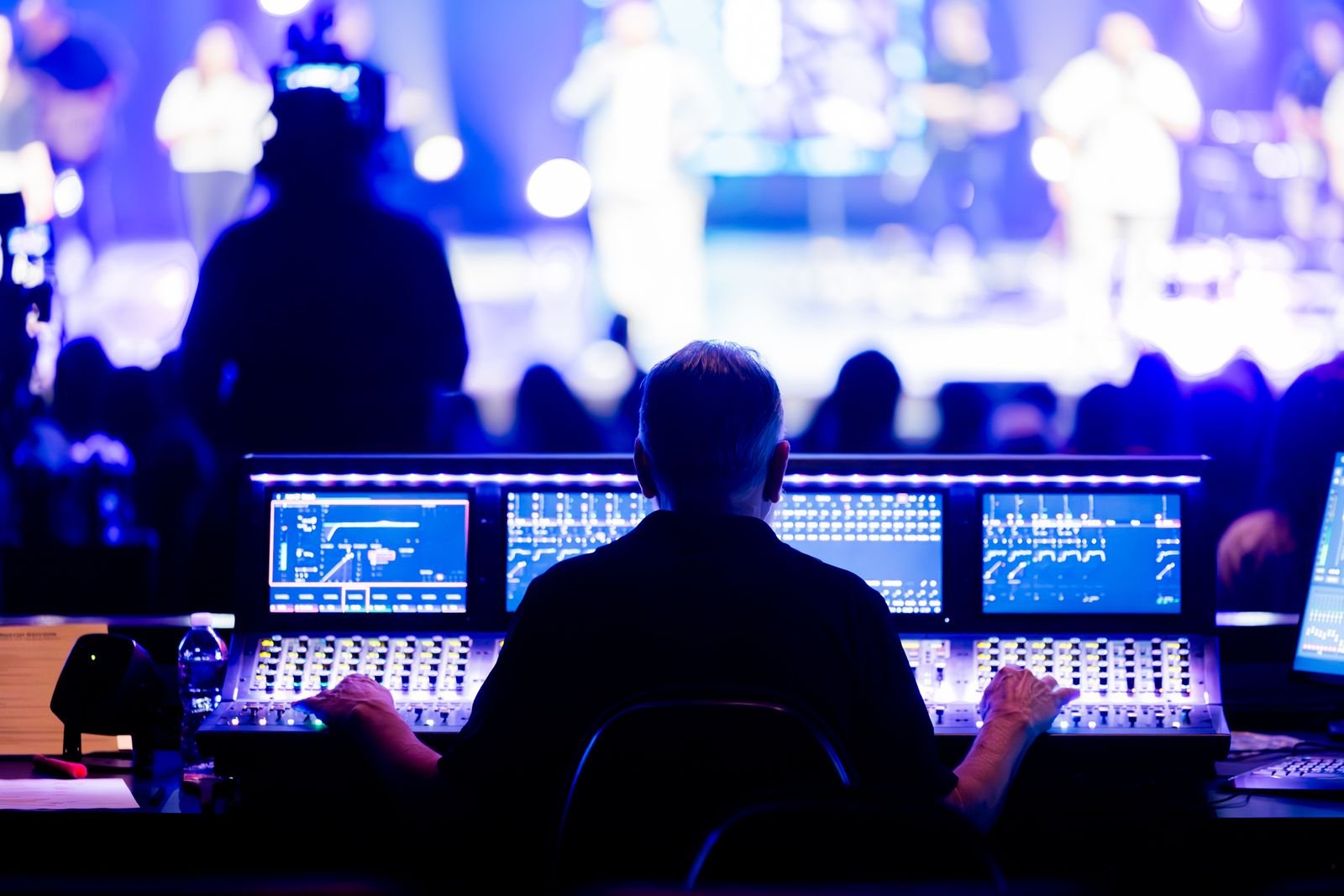 Técnico de som operando mesa de mixagem digital durante evento ao vivo