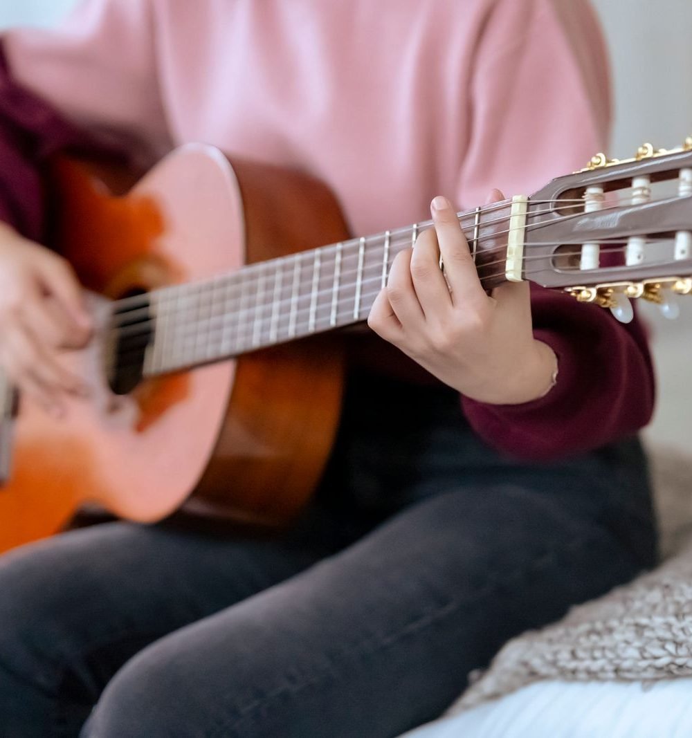 Musicista tocando violão acústico em ambiente intimista