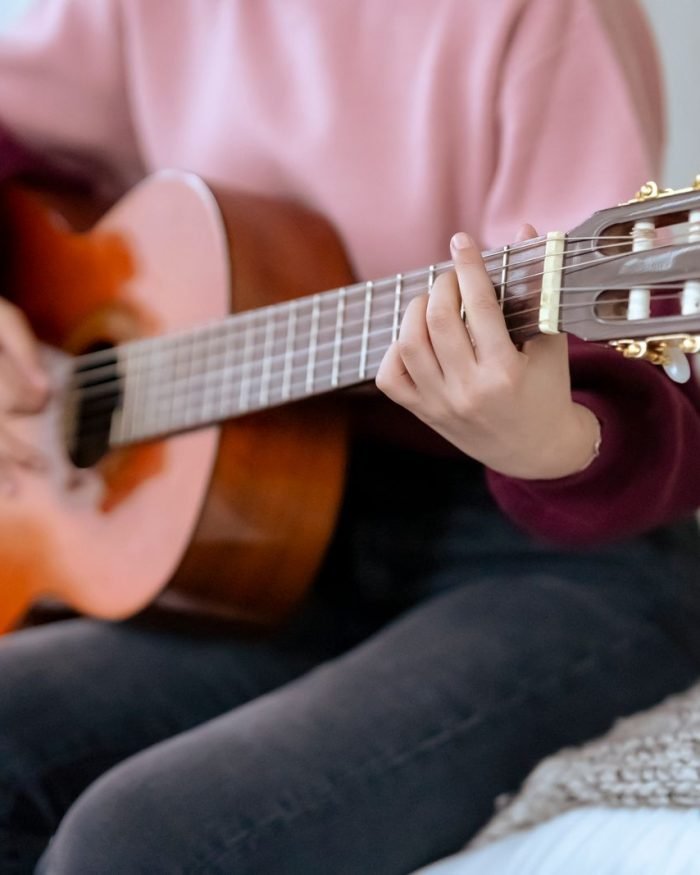 Musicista tocando violão acústico em ambiente intimista