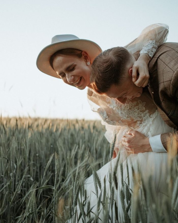 Casal sorridente em campo ao entardecer