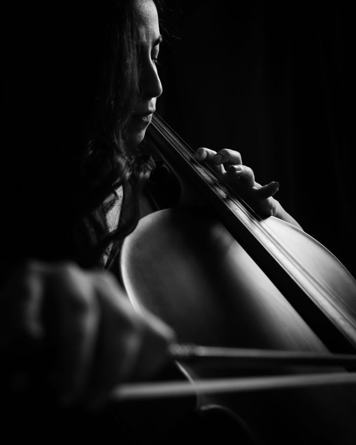 Violoncelista tocando com intensidade em retrato em preto e branco